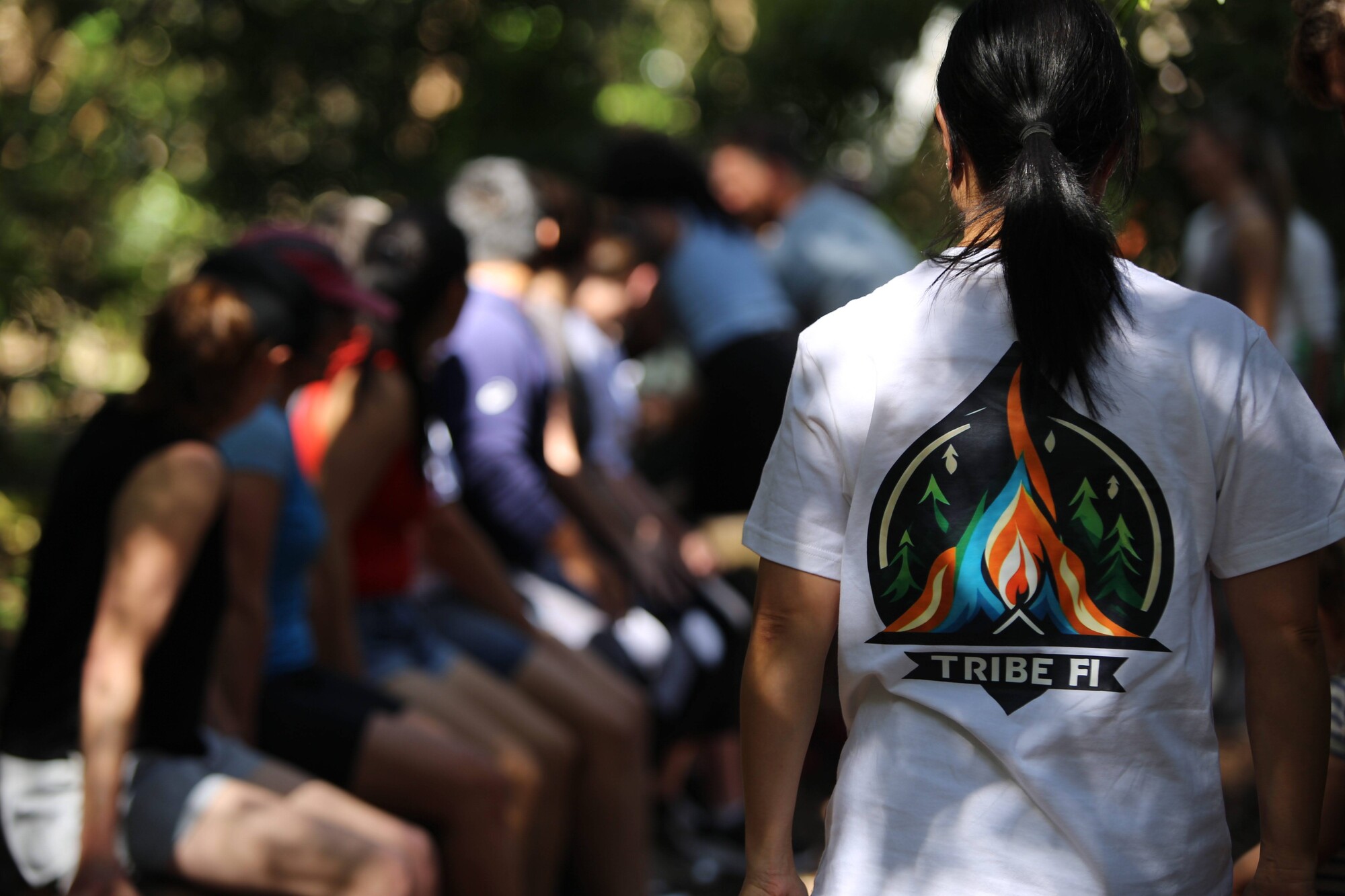 Members in Tribe FI shirts gathered outdoors between sessions